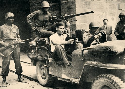 Buffalo Soldiers escorting a German captured in civilian clothes outside the Lucca.